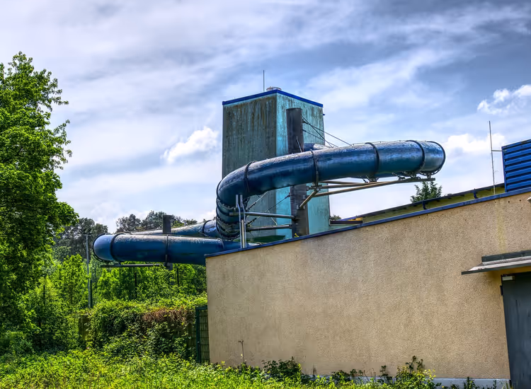 Blauwe overdekte waterglijbanen op een waterparktoren