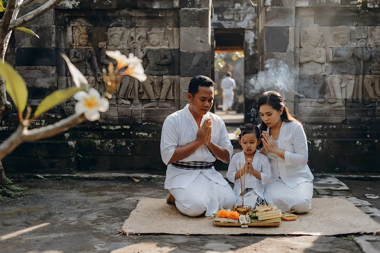 Bir tapınakta sunularla dua eden Bali'li aile
