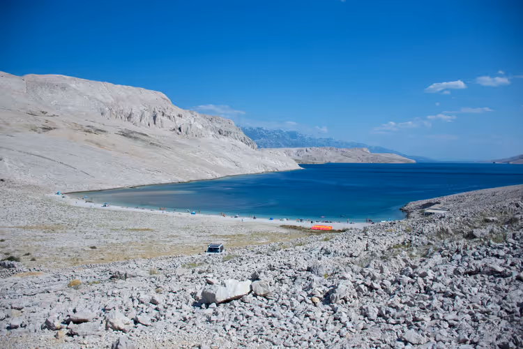 Rotsachtige kust en turquoise baai op Pag
