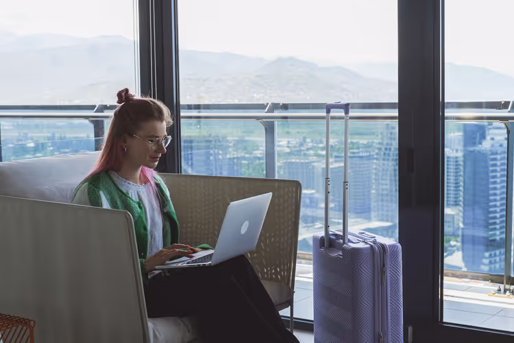 Kvinne med laptop og koffert i en hotellobby