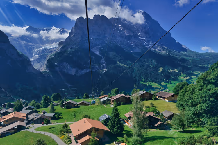 Landsbyen Grindelwald med sveitserhus mot en bakgrunn av alpine fjell