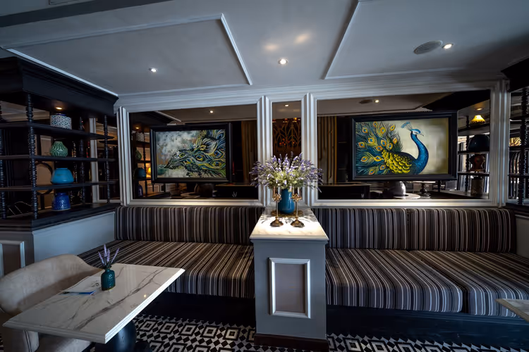 Hotellobby met sofa's en een schilderij van een pauw