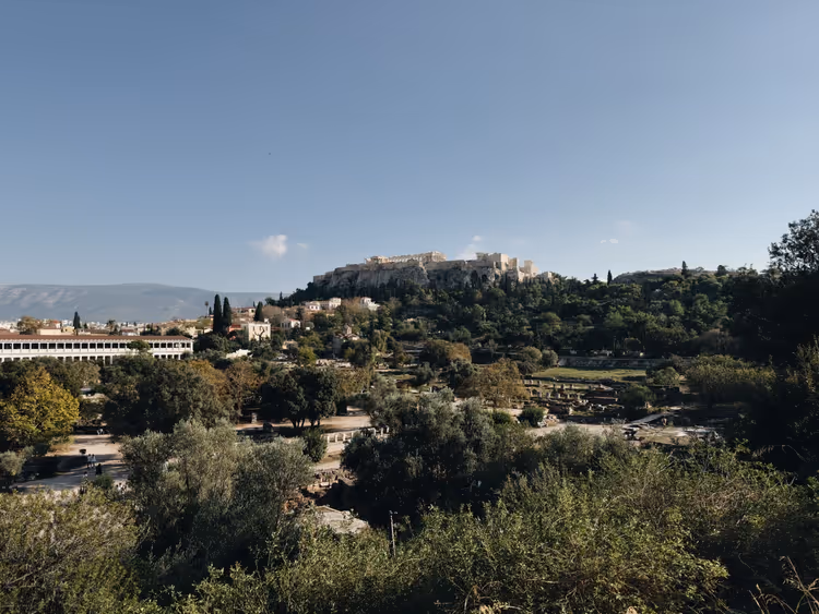 Akropolis auf ihrem Felshügel über der grünen Antiken Agora und der Stoa des Attalos in Athen unter klarem Himmel