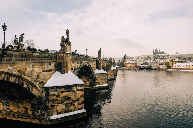 Charles Bridge in winter with snowy rooftops
