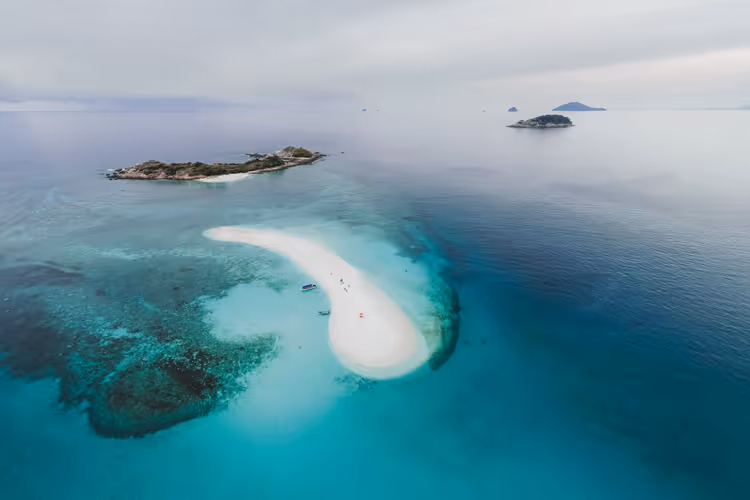 Flyfoto av tropiske øyer med en sandbanke og turkisblått vann