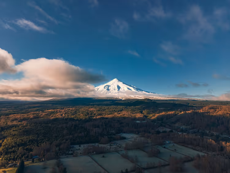 Şili'nin ormanları ve tarlalarının üzerindeki Villarrica Yanardağı