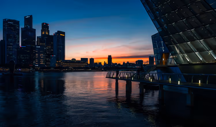 Singapur bei Nacht: Lichter der Marina Bay spiegeln sich im Wasser