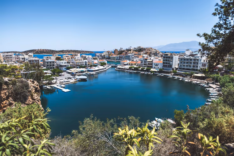 Blick auf den Hafen von Agios Nikolaos mit Booten und Häusern