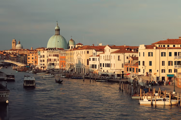 Het Canal Grande, vaporetto en de kerk San Simeone bij zonsondergang