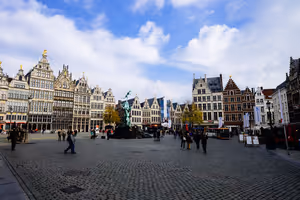 Kullerstensbelagda Grote Markt i Antwerpen med utsmyckade skråhus med gavlar, Brabofontänen och människor som går över torget