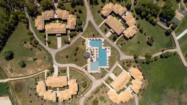 Fugleperspektiv av villaer og hotellbasseng