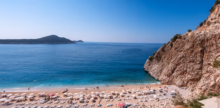 Kaputas Beach met parasols bij de klif en turquoise water