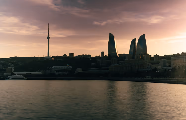 Panorama al tramonto di Baku con le Flame Towers e la torre TV