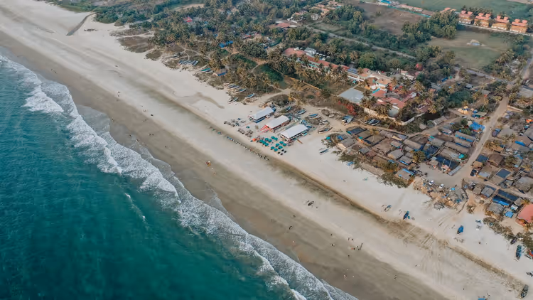 Luchtfoto van Utorda Beach en het dorp in Goa