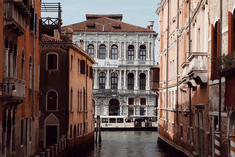 Det barokke palasset Ca' Rezzonico over en venetiansk kanal med en vaporetto