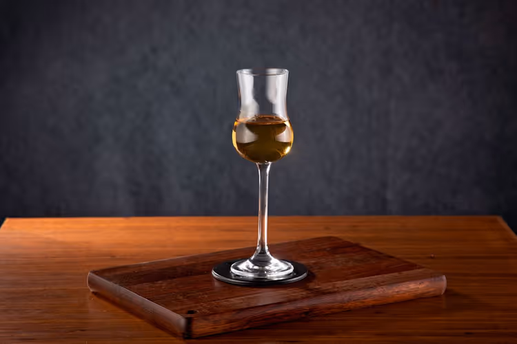 Glass of strong drink on a wooden table