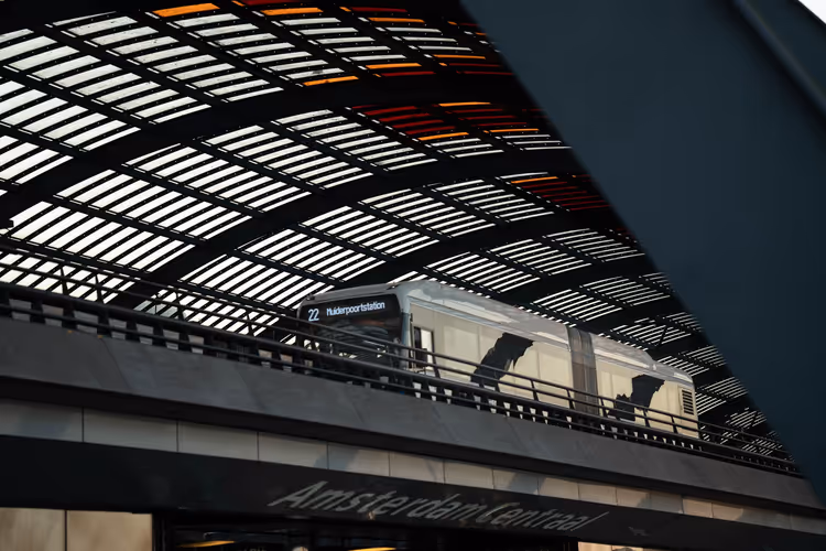 Intercity train under the geometric roof of Amsterdam Centraal station