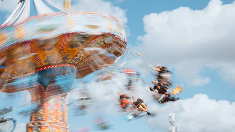 vervaagde carrousel met mensen tegen de lucht