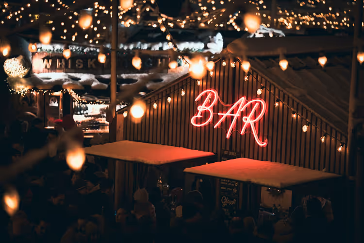 Nattlig gatebar med neonskilt og lyskjede