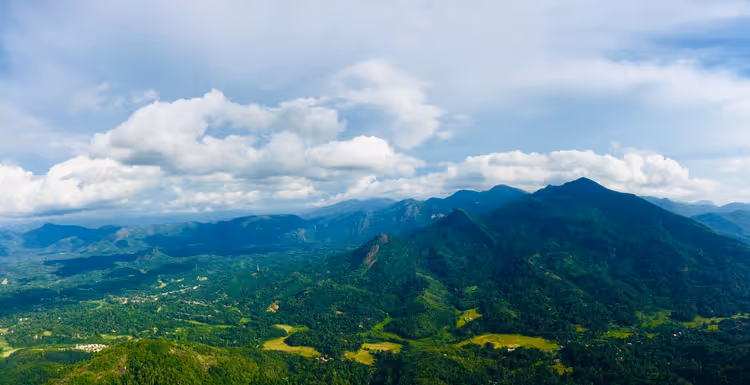 Grüne Berge und Täler von Kegalle unter wolkenverhangenem Himmel