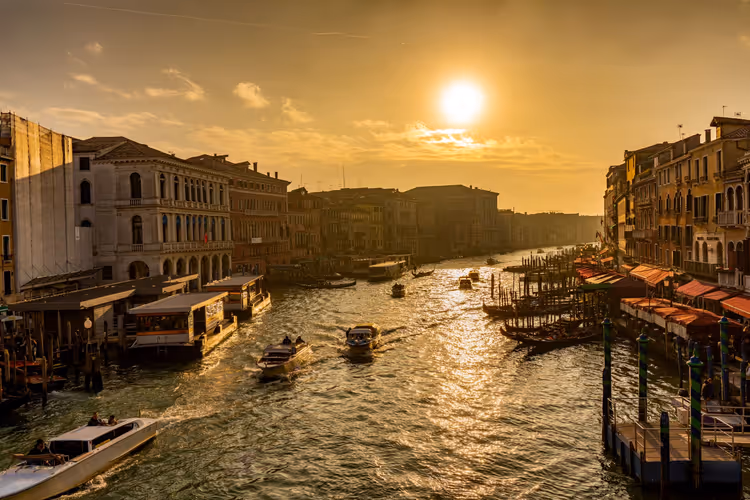 Sonnenuntergang über dem Canal Grande in Venedig mit Gondeln und Booten