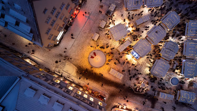 Marché de Noël nocturne sur une place vu d'en haut