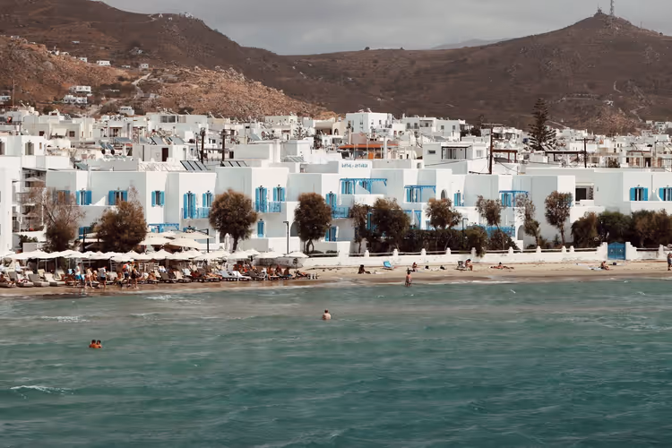 Strand op Naxos met witte huizen en blauwe luiken