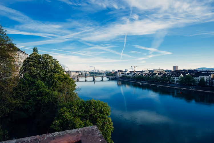 Der Rhein und grüne Uferböschungen in Basel
