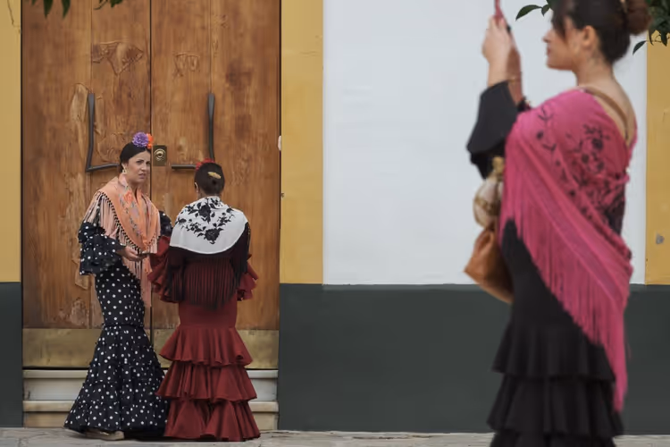 Mulheres com vestidos de flamenca numa rua de Sevilha