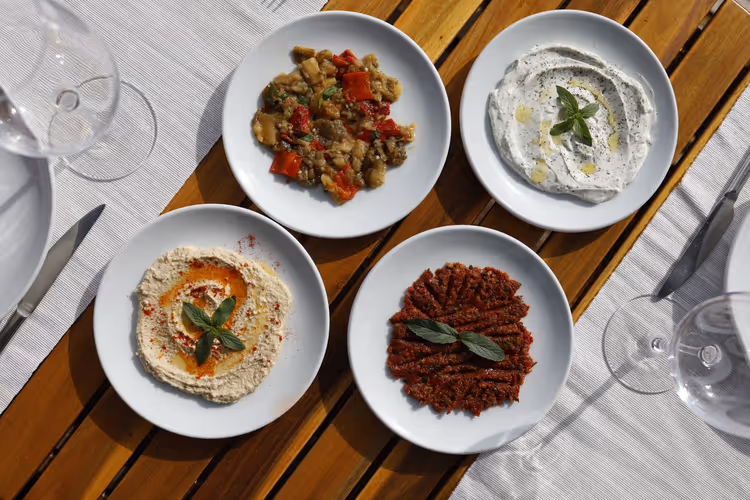 Griechische Meze-Vorspeisen auf einem hölzernen Tavernentisch