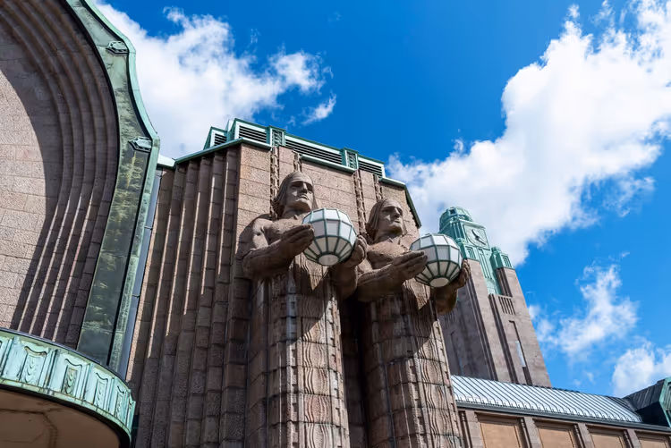 Stenen lantaarnopstekers op de gevel van het Centraal Station van Helsinki