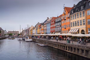 Bunte Giebelhäuser, Caféschirme und vertäute Holzboote am Nyhavn-Kanal in Kopenhagen