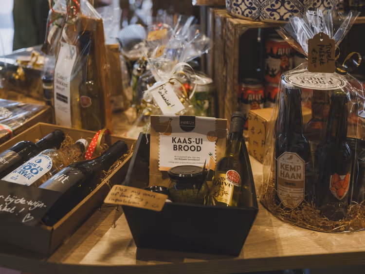 Niederländische Geschenkkörbe mit Bierflaschen, Wein, Olivenöl und einer Backmischung für Käse-Zwiebel-Brot auf einem Ladentisch