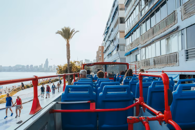 Turister på en åpen buss langs vannkanten