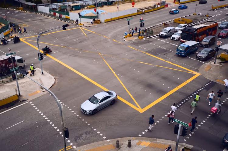 Kreuzung in Singapur mit Fußgängern und Autos