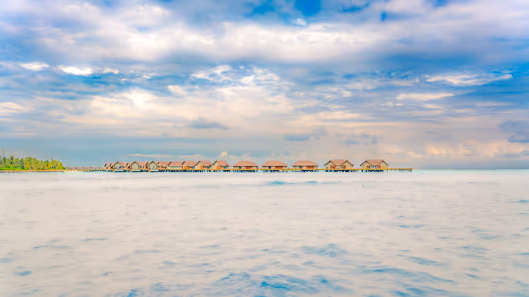 Overwaterbungalows op palen in de kalme Maldivische oceaan