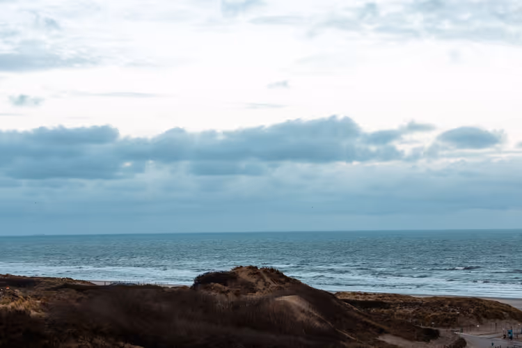 Dünen und die Nordsee unter einem bewölkten Himmel