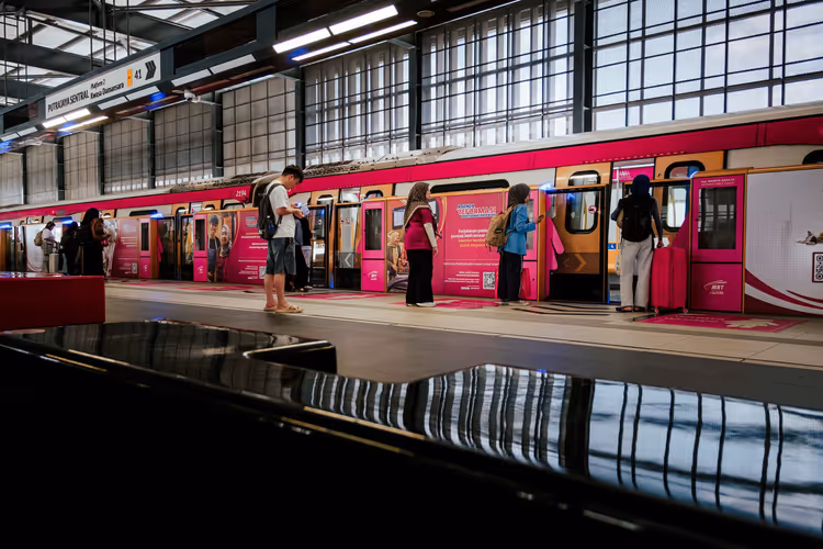 Passagers attendant un train rose sur le quai de la gare