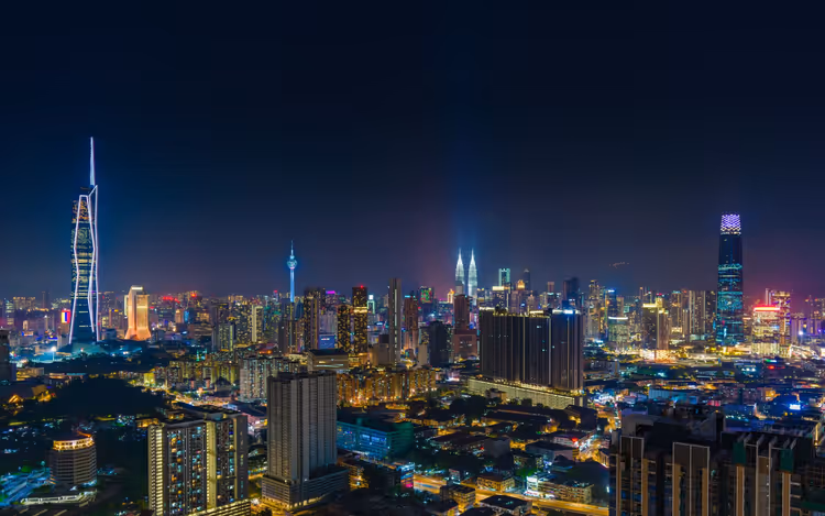 Skyline von Kuala Lumpur bei Nacht mit den Petronas Towers, dem KL Tower und beleuchteten Wolkenkratzern über den Lichtern der Stadt