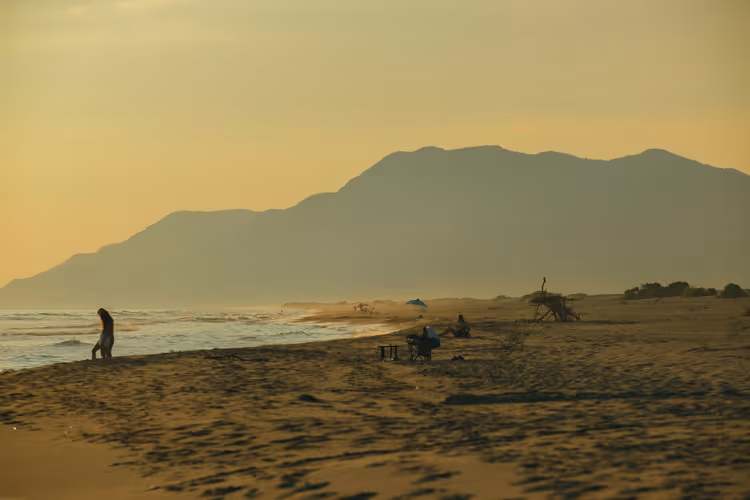 Zandstrand van Patara Beach in de schemering met silhouetten en bergen