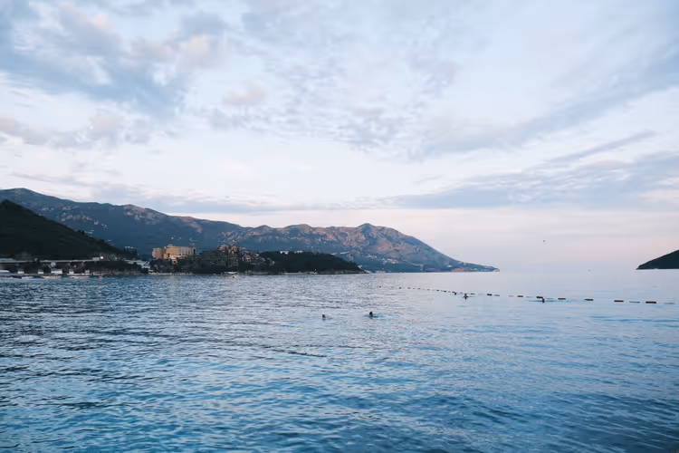 Stille hav utenfor Budva-kysten med fjell i det fjerne