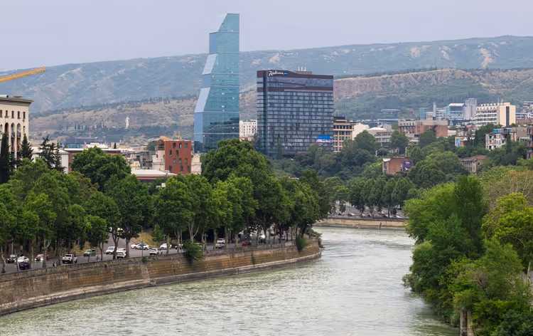 Panorama over Tbilisi med Mtkvari-elven og høyhus