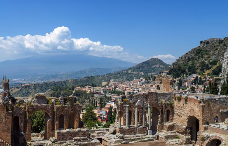 Arka planda Etna Yanardağı ile Taormina'daki Yunan tiyatrosunun kalıntıları