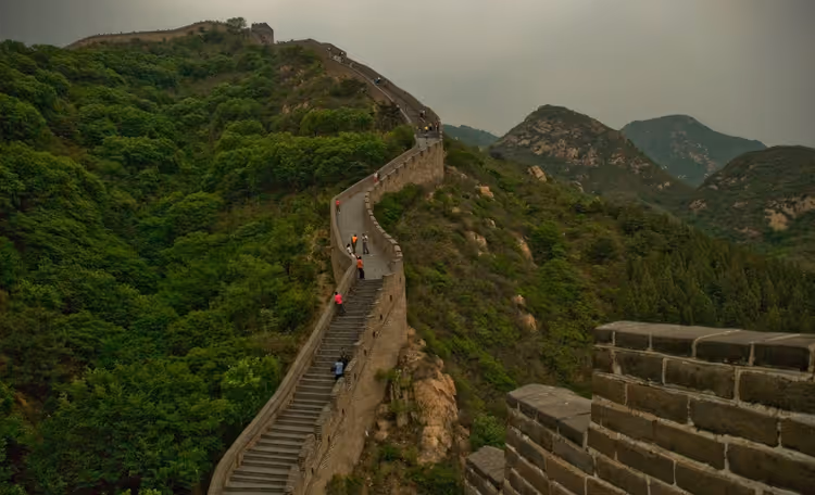 Chinesische Mauer, die sich durch grüne Berge schlängelt