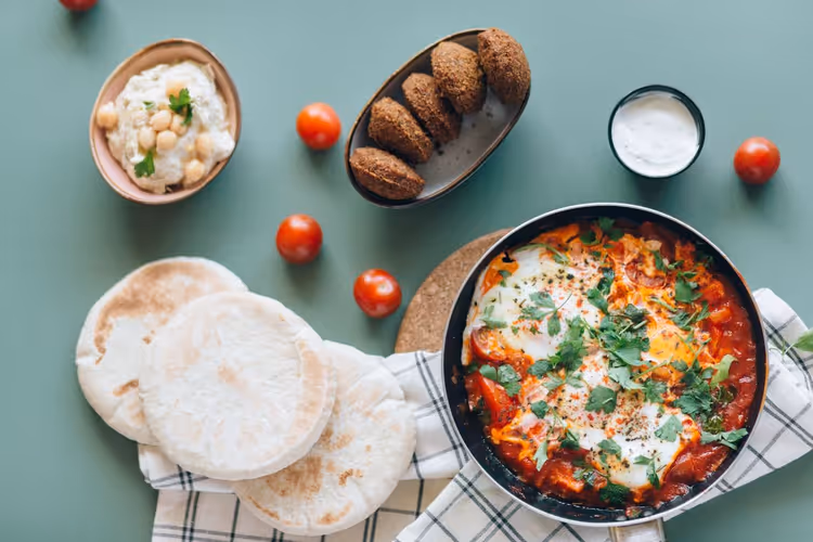 Hummus, Falafel und Shakshuka mit Pita auf dem Tisch
