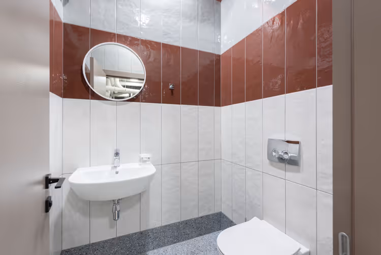 Modernes Badezimmer mit Waschbecken, Spiegel und Toilette