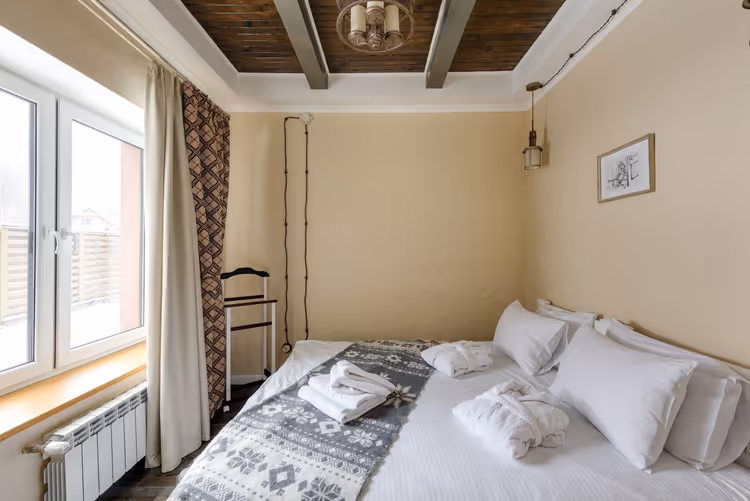 Chambre lumineuse avec un lit double et une fenêtre