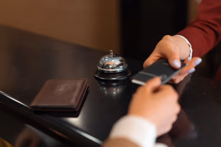 Receptie van hotel, handen met plattegrond en smartphone