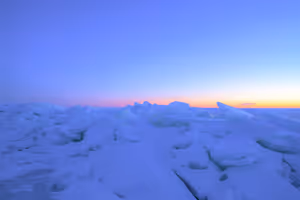 Grillig pakijs in blauwe schemering met een strook oranje en roze gloed langs de horizon