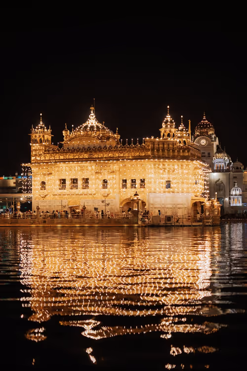 Il Tempio d'Oro di Amritsar di notte con il riflesso nell'acqua